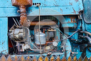 View of an old oiled and rusted tractor engine, background