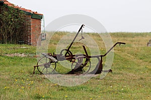 View on an old plow on a grass area at the northern sea island juist germany