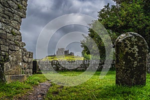 View through old ruins of Hore Abbey and tombstone on Rock of Cashel castle