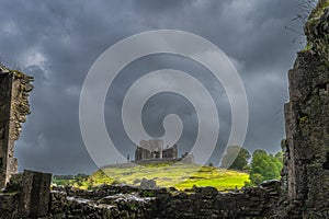 View through old ruins of Hore Abbey walls on Rock of Cashel castle with dark dramatic storm sky