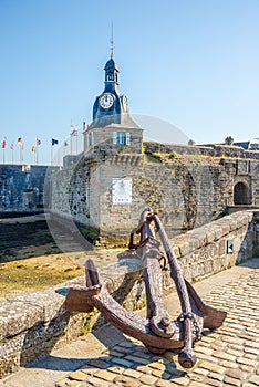 View at the Old rust Anchor and Clock tower of Fortress in Concarneau town, France photo