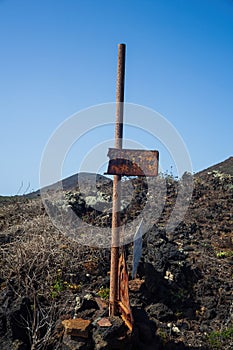 View of an old rusty signage on the lava hill, Linosa