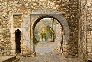 View through old stone arc on pavement