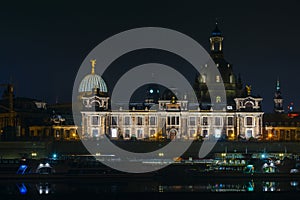 View of the old town of Dresden at night with a view of water and the reflection of the city as well as, churches, towers and bui