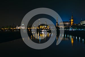 View of the old town of Dresden at night with a view of water and the reflection of the city as well as, churches, towers and bui