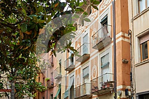 View of old town Girona, Catalonia, Spain, Europe. Summer travel. Eco-friendly building in the city. Green tree branches