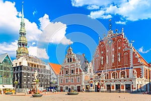 View of the Old Town Ratslaukums square, Roland Statue, The Blackheads House and St Peters Cathedral against blue sky in Riga,