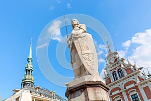 View of the Old Town square, Roland Statue, The Blackheads House and St Peters Cathedral against blue sky in Riga, Latvia. Summer