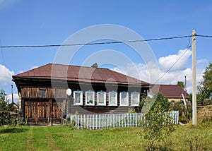 View of the old traditional wooden house with beautiful carved windows. Village of Visim, Sverdlovsk oblast, Russia