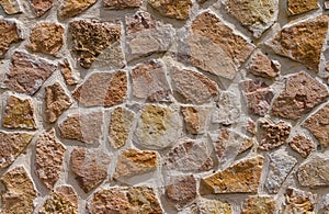 View of old wall built with stones in warm tones.