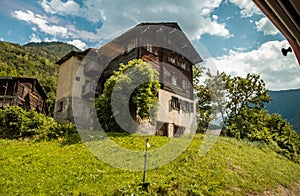 View of the old wooden brown wall house with vintage windows. Typical wooden house in Switzerland