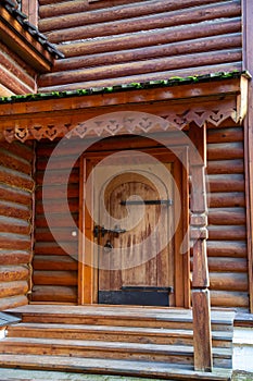 View of an old wooden porch with a staircase, forged metal hinges, locks, beautiful decorative decoration outside the canopy