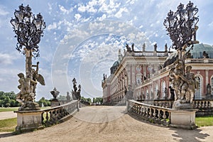 View of one of the entrances of Das Neue Palast with its baroque statues, wrought iron lanterns, and a part of the palace garden photo