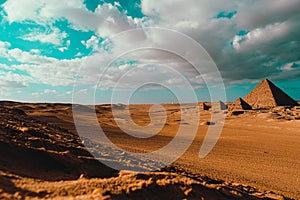 View of one of the great pyramids of giza in cairo ,egypt , and several other smaller ones around them. Wide view of the desert