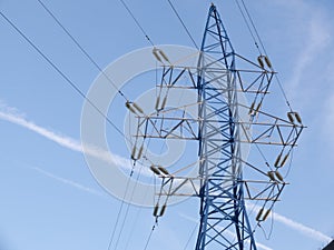 View on one outdoor high voltage electric transmission line support metal construction tower pillon on blue cloudy sky