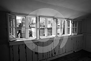 View through the open windows from the top floor of and old Georgian house in Princelet Street, London UK.