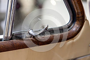 View on opened front door with chrome handle for opening the corner window of the old Russian car of the executive class