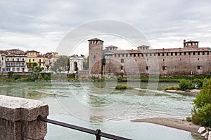 View  from the opposite shore to the Castelvecchio Bridge fortress, the embankment and Arco dei Gavi in old part of Verona, city