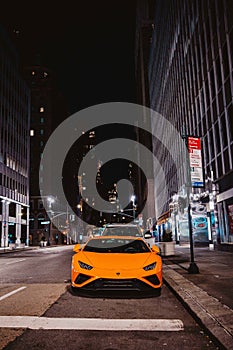 View of an orange luxury Lamborghini car parked on a street