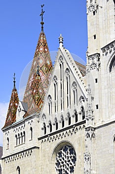 View of ornately colored tile roof of St. Matthias Church on blue sky background. Fisherman`s Bastion in Budapest