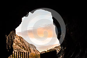 View out of a cave in hily landscape