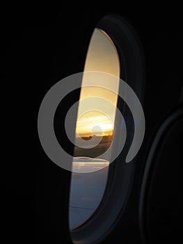 a view out of dharma van window of the wing of a plane with the sun