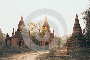 View over ancient temples of Bagan complex during sunrise golden hour in Myanmar