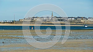 View over bay during low tide from Dinard on cityscape of breton town Saint Malo against dizzy sky