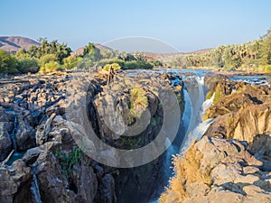 View over beautiful scenic Epupa Falls on Kunene River between Angola and Namibia in evening light, Southern Africa