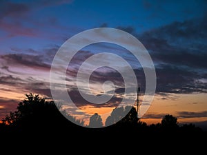 View over a beautiful sunset behind a radio antenna tower