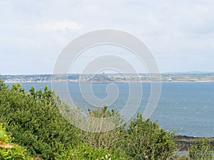 View over bushes at Moushole to the blue sea of the Cornish coast and Saint Michael\'s Mount Cornwall England