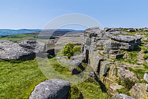 A view over a crevice in the millstone cap on the highest point on the top of the Stanage Edge escarpment in the Peak District, UK