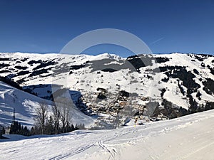 View over empty skiing slopes down in the valley of Saalbach-Hinterglemm