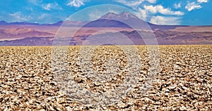 View over endless dry salt flat crust on blurred mountain range, volcano Licanabur - Salar de Atacama, Chile