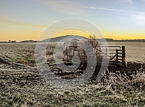 A view over the frost-covered fields and the early morning mist towards the Wrekin hill at Wroxeter, UK