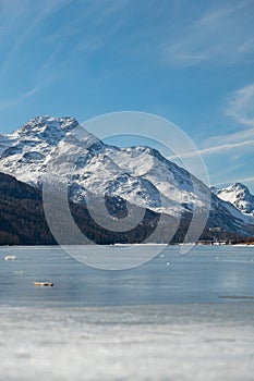 View over the frozen lake of Silvaplana and the peak of the mount Corvatsch in the background