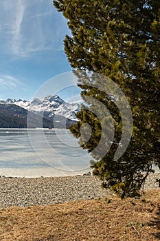 View over the frozen lake of Silvaplana and the peak of the mount Corvatsch in the background