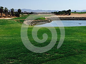 View over Golf hole in Spain with water hazard in front