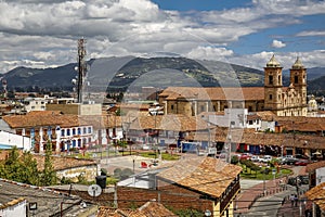 View over historic town Zipaquira with colonial buildings, Parque principal, Cathedral of Zipaquira and mountains, blue sky with