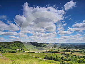 View over Hope Valley and Lose Hill with billowing white clouds and blue sky, Peak District, UK