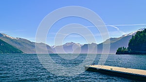 View over jetty pier, fjord lake and mountains