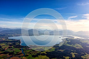 view over Lake Chiemsee to the Alps with clouds and blue sky