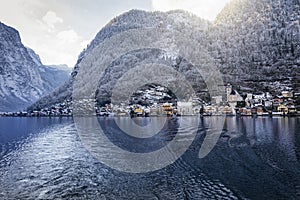 View over the lake of Hallstatt to the little village beneath the snow covered mountains