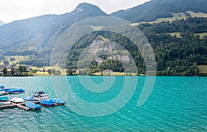 View over the Lake Lungern. Lungernsee is a natural lake in Obwalden. Wooden pier with boats. Beautiful lake with