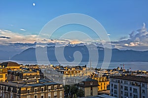 View over Lausanne roofs at sunset with lake Geneva and Alps