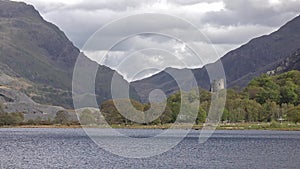 View over Padarn Lake, Llanberis, Snowdonia in Wales with the historic castle Dolbadarn remains in background