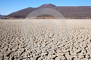 View over parched and empty dam, with cracked mud