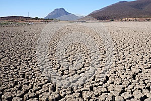 View over parched and empty dam, with cracked mud