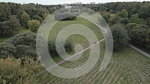 View over the park with a drone walking people green alley in the city of summer day