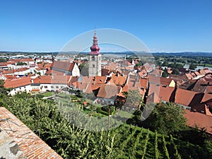 View over Ptuj Old Town - church bell and red roofs photo